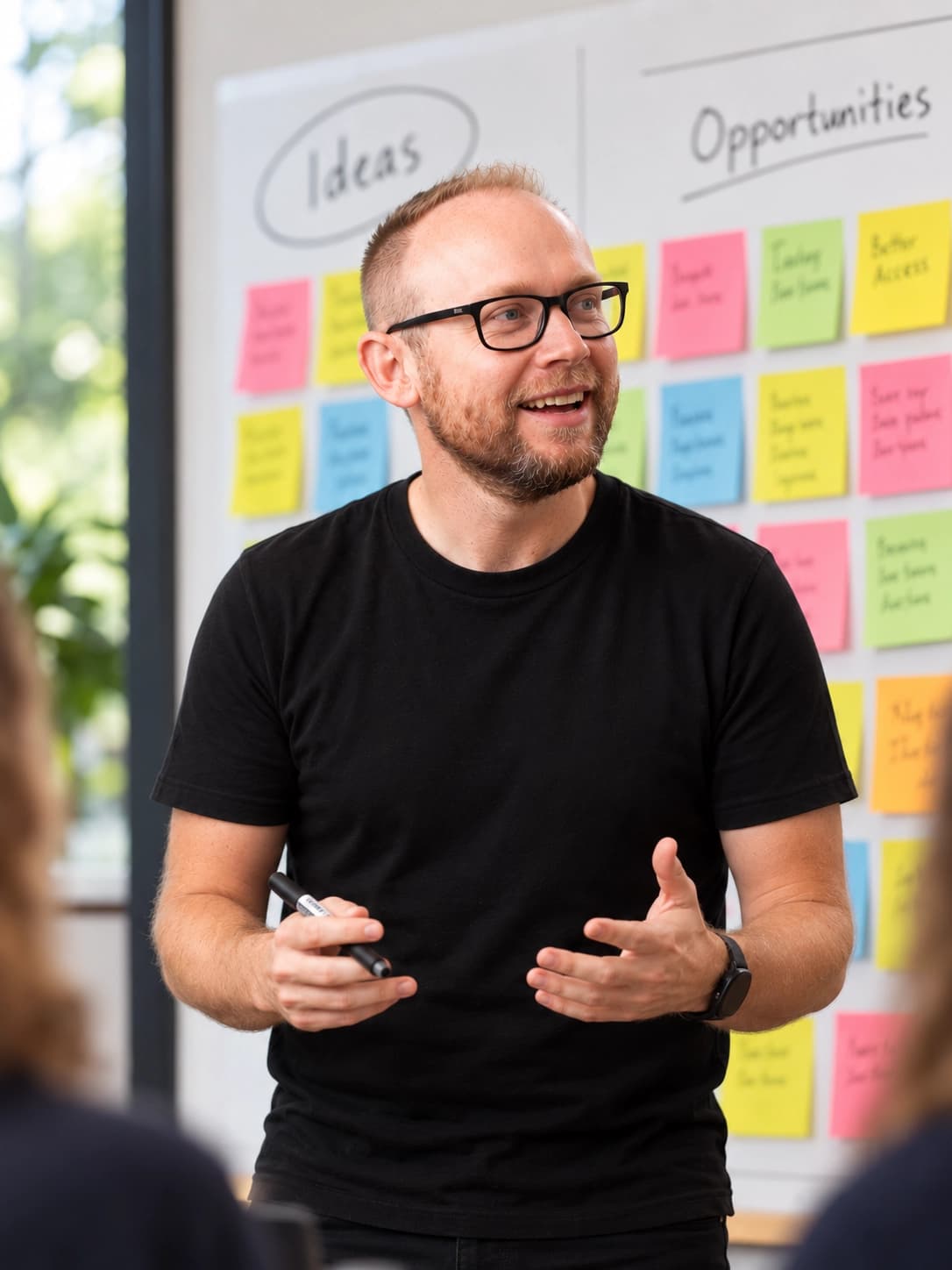 John running a workshop in front of a wall of sticky notes